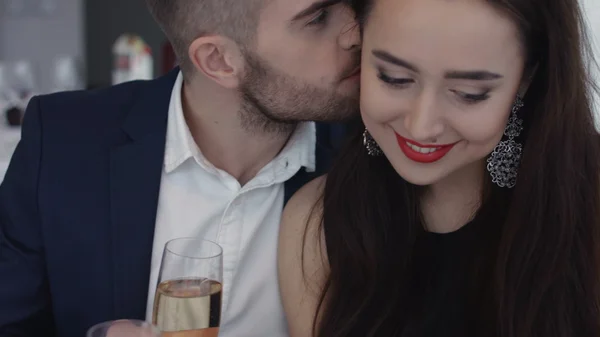 Restaurante, pareja y concepto de vacaciones - pareja sonriente con una copa de champán mirándose en el restaurante — Foto de Stock