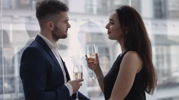 Restaurante, pareja y concepto de vacaciones - pareja sonriente con una copa de champán mirándose en el restaurante —  Fotos de Stock