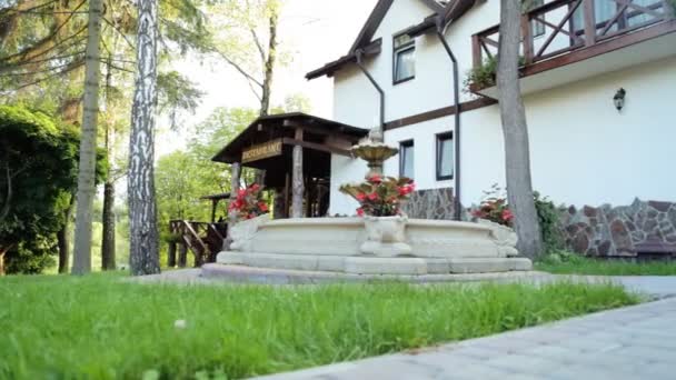 De fontein en rode bloemen in de buurt van buitenterras van luxe restaurante — Stockvideo