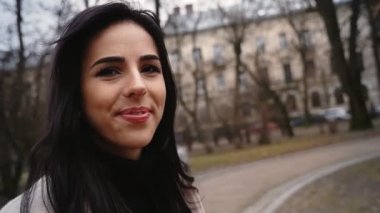 Bir kameraya bakarak mutlu gülümseyen kadın.