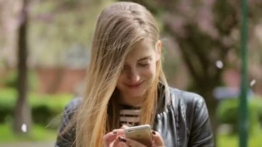 Sokakta kalan telefonunu kullanarak sevimli genç bayan.