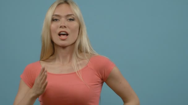 Портрет красивой блондинки, дарящей воздушный поцелуй над синим фоном — стоковое видео