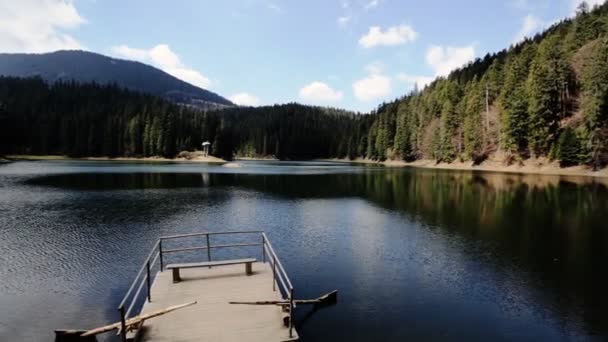 Increíble vista del pequeño muelle de madera viejo y el paisaje de bosque, lago rodeado de montañas, hermosa escena colorida — Vídeo de stock