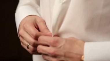 Bir damat düğün için hazırlanıyor ve siyah şık takım elbise kadar kadar düğmelerini kapat.