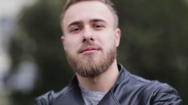 Gri gözleri bir kameraya bakarak seksi yakışıklı adam.