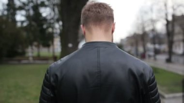 Sokakta yürürken ve telefonda konuşurken adam.