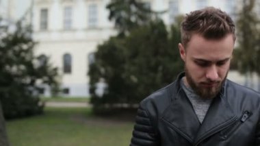 Bir kameraya gülümseyen genç yakışıklı adam.