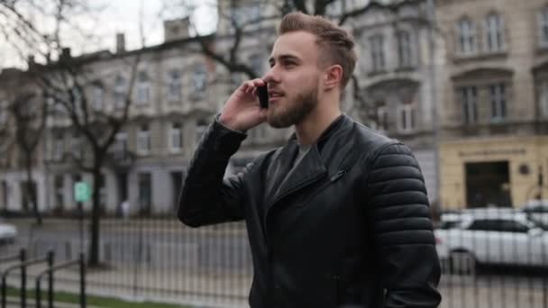 Snygg ung kille pratar på sin telefon på gatan. — Stockvideo