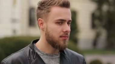 Genç yakışıklı bir kameraya bakıyor.