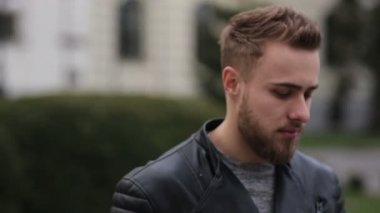 Sokağın ortasında gülümseyen genç adam.