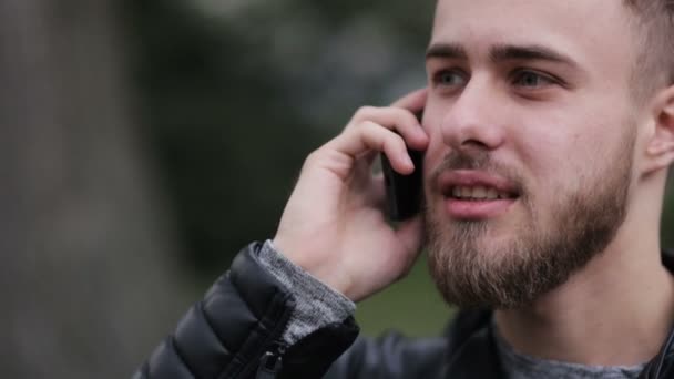 Joven hablando por teléfono al aire libre . — Vídeo de stock