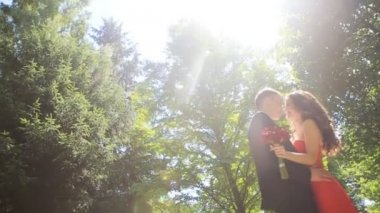 Yaz aylarında parkta duran bir zarif kırmızı elbise düğün çifti