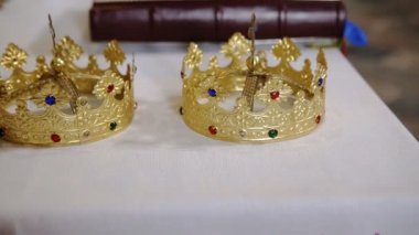 İki altın kron ve İncil'in düğün töreni için hazırlanan beyaz masa üzerine