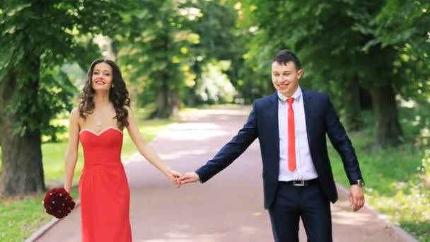 Un couple marchant dans le parc et dansant — Video