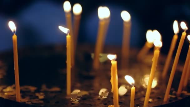 Bougies votives brûlant dans une cathédrale sombre . — Video