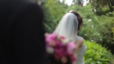 Takip et beni. Beyaz duvak güzel genç gelin damat buket ile el havada tutar..