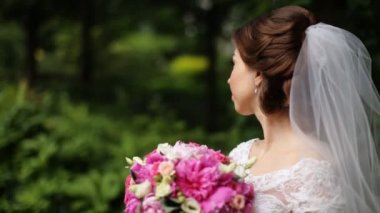 Esmer gelin giyiyor peçe holding Pembe buket kamera parkta bakarak gülen