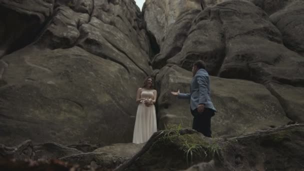 Свадебная пара целуется на закате в горах — стоковое видео