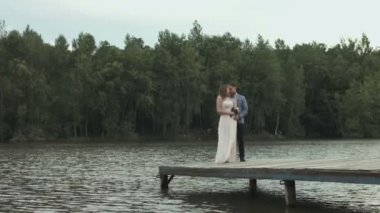 seven ayakta ve su kenarında öpüşme düğün Çift.