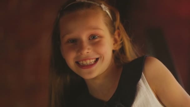 Kislány nézi a kamerát, és mosolyogva, közelkép, felülnézet — Stock videók