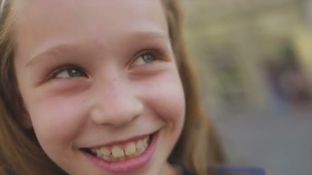 Крупним планом молода дівчина посміхається, коли вона дивиться в камеру — стокове відео
