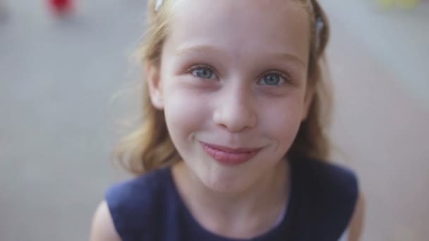 Primo piano di una giovane ragazza sorridente mentre guarda nella fotocamera — Video Stock