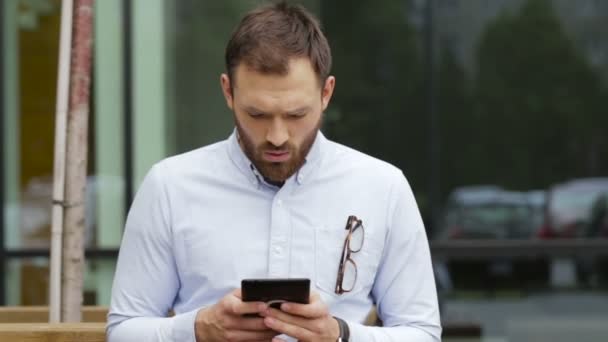 Timido giovane uomo che utilizza il suo tablet in strada . — Video Stock