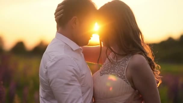 Schönes Hochzeitspaar küsst sich am Sonnenuntergang in den Bergen — Stockvideo