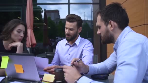 Equipo de tres trabajadores mirando la pantalla del ordenador portátil — Vídeos de Stock