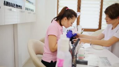 Çekici bir manikürcünün portresi düzenli müşterilerinden birine manikür yapıyor.