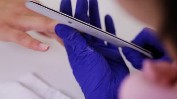 Närbild på kosmetolog i handskar arkivering kvinnliga klienter naglar på spa skönhetssalong — Stockvideo