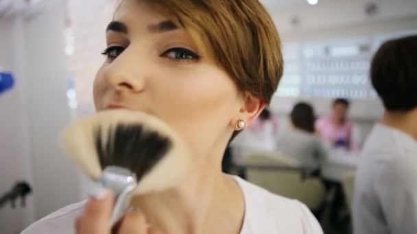 Mujer divertida juega con el cepillo de maquillaje mirando a la cámara. Maquillaje creativo artista — Vídeo de stock