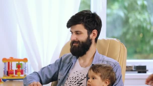 Mutlu genç oğlu ile çift masa başında, genç kadın öpüşme dizüstü kullanarak adam sakallı — Stok video