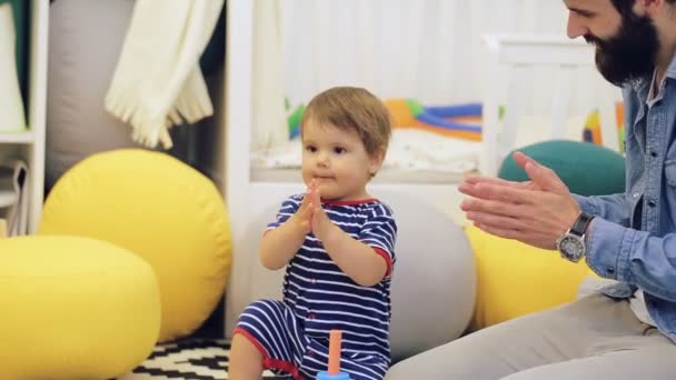 Familjen koncept - glad pappa och Lille son leker med leksak block hemma — Stockvideo