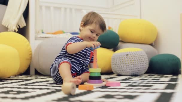 Anak manis berjas biru bermain menara berwarna-warni di lantai — Stok Video