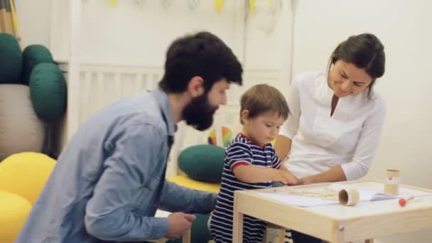 Gelukkig kind schilderij samen met ouders thuis — Stockvideo