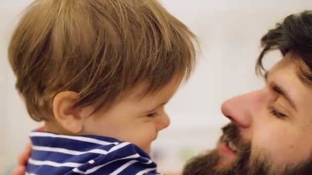 Vrolijke jongeman lift omhoog zijn trots van de baby in de slaapkamer, schoot thuis — Stockvideo