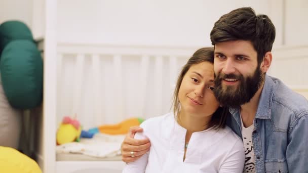 Jeune couple profitant d'un moment de détente ensemble couché bras dans le bras sur le canapé en regardant leur fils apprendre à marcher — Video