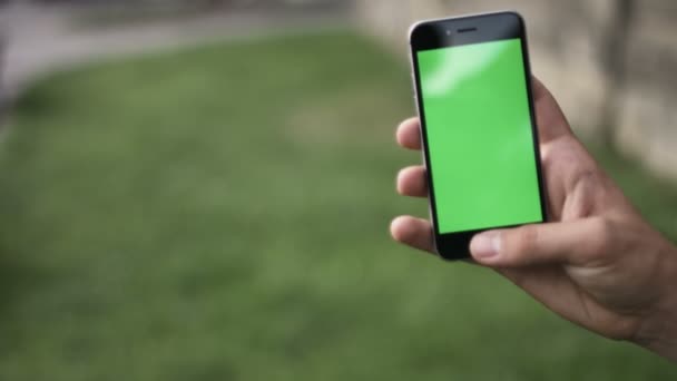 Держа сенсорное устройство, крупным планом женские руки с помощью смартфона. цветная клавиша, зеленый экран — стоковое видео