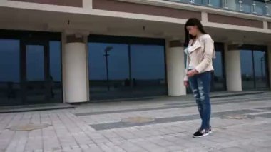 Trendy bir görünüm ayakta modern ofis binası yakınındaki bir genç şık hipster kızla tam uzunlukta portresi