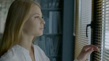 büyük parlak pencere perde ve güneşlik bakarak mutlu bir kadın