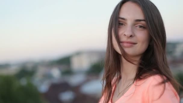 Close up retrato de menina morena bonita com cabelos longos sorrindo, girando e olhando para a câmera — Vídeo de Stock