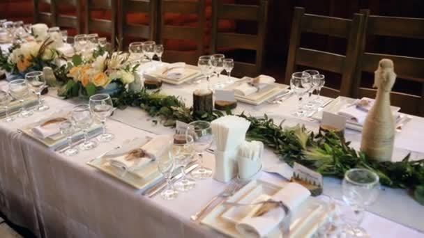 Rosas brancas com estante de vegetação na mesa de jantar festiva servida — Vídeo de Stock