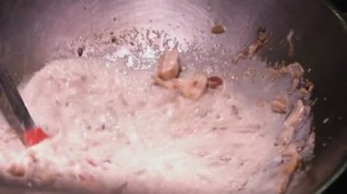 Closeup karıştırma mantar, et, deniz ürünleri ve tereyağı bir kızartma wok tava