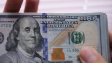 Yakın çekim yüz dolar faturaları bir masada sayma bir businessmans el