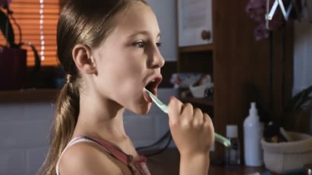 Niña en pijama rosa lavando y cepillando los dientes en el baño — Vídeo de stock