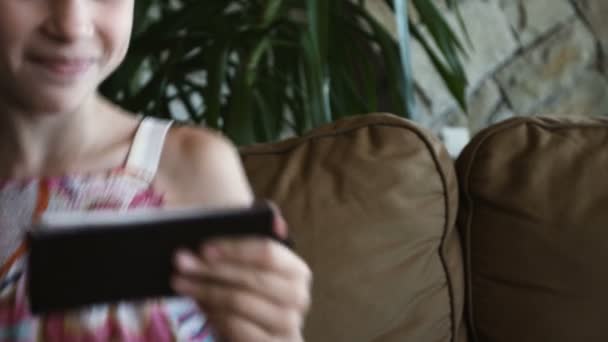 Primer plano retrato niño. Chica en ropa rosa usando el teléfono móvil y sonriendo — Vídeo de stock