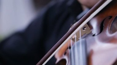 Kemancı adam siyah bir arka planda keman çalıyor. Yakın çekim.