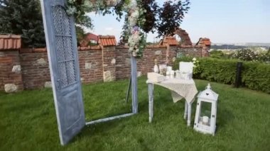 Ahşap Dekoratif ışıklar, kemer ve tablo, çiçeklerle süslenmiş. Dekorasyon düğün töreni yerinde