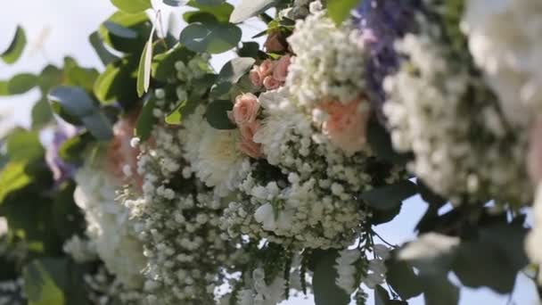 Γκρο πλαν του μέρους του αψίδα γάμου με ροζ και λευκά λουλούδια — Αρχείο Βίντεο